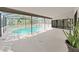 Screened-in pool area with clear blue water, a spacious deck for lounging, and views of trees at 8124 Golf Club Ct, Hudson, FL 34667