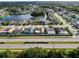 Wide aerial view showcasing neighborhood homes surrounding a scenic pond, with mature trees and landscaping at 8127 Tarsier Ave, New Port Richey, FL 34653
