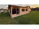 Exterior view of the home featuring a screened-in porch and a grassy yard at 8127 Tarsier Ave, New Port Richey, FL 34653