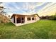 Spacious backyard featuring a screened-in patio, lush green grass, and a partially visible gazebo at 8127 Tarsier Ave, New Port Richey, FL 34653