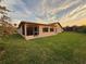 Back exterior view of the property with green lawn and flower bush at 8127 Tarsier Ave, New Port Richey, FL 34653