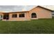 Large grassy backyard with a peek at the rear house facade at 8127 Tarsier Ave, New Port Richey, FL 34653