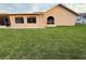 View of the back exterior of the house and green lawn at 8127 Tarsier Ave, New Port Richey, FL 34653
