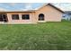 A view of the back exterior of the house and grassy lawn at 8127 Tarsier Ave, New Port Richey, FL 34653