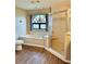 Bathroom with a soaking tub, separate shower, and wood-look flooring at 8127 Tarsier Ave, New Port Richey, FL 34653