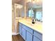 Bathroom featuring blue cabinets, new countertop, modern fixtures, shower and bath combo at 8127 Tarsier Ave, New Port Richey, FL 34653