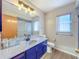 Updated bathroom featuring blue cabinets, updated counters, and a glass shower at 8127 Tarsier Ave, New Port Richey, FL 34653