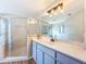 Bright bathroom featuring a glass shower, spacious vanity, and large mirror at 8127 Tarsier Ave, New Port Richey, FL 34653