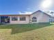 Exterior of home featuring a backyard, side windows and sliding glass door at 8127 Tarsier Ave, New Port Richey, FL 34653