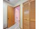 Hallway featuring wood-look tile floor, an open doorway and wood closet doors at 8127 Tarsier Ave, New Port Richey, FL 34653