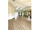 Spacious living area with wood-look flooring, mirrored wall, and ample natural light at 8127 Tarsier Ave, New Port Richey, FL 34653