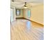 Spacious living room featuring wood-look floors, a ceiling fan, and natural light from multiple windows at 8127 Tarsier Ave, New Port Richey, FL 34653