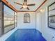 Enclosed back patio with decorative security window, fan and blue floor at 8127 Tarsier Ave, New Port Richey, FL 34653