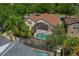 Aerial view of a home with a screened-in pool and landscaped yard, surrounded by mature trees at 8211 Canyon Creek Way, Tampa, FL 33647