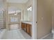 Bright bathroom featuring double sinks, tile flooring, walk-in shower and a separate soaking tub at 8211 Canyon Creek Way, Tampa, FL 33647
