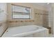 Close-up of bathroom with large soaking tub and tiled walls, providing a luxurious experience at 8211 Canyon Creek Way, Tampa, FL 33647