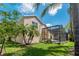 Lawn view of a house featuring a screened pool, complimented by lush landscaping at 8211 Canyon Creek Way, Tampa, FL 33647