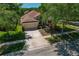 Aerial view of a home with a well-manicured lawn, mature trees, and a paved driveway at 8211 Canyon Creek Way, Tampa, FL 33647