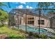 Backyard view of the screened pool area, showcasing the home's spacious layout at 8211 Canyon Creek Way, Tampa, FL 33647