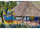 Outdoor view of Coco's Crush Bar & Grill sign with a thatched roof structure against lush green vegetation at 829 E Gulf Blvd # 107, Indian Rocks Beach, FL 33785