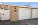 Attached one car garage with white door on tan stucco building with white trim and red brick sidewalk and gate at 829 E Gulf Blvd # 107, Indian Rocks Beach, FL 33785