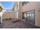 Wide shot of the rear patio with brick pavers, with sliding glass doors into the home at 829 E Gulf Blvd # 107, Indian Rocks Beach, FL 33785