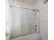 Standard bathtub with a shower head and a sliding translucent glass door at 829 E Gulf Blvd # 107, Indian Rocks Beach, FL 33785