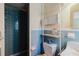 Bathroom showcases blue tiling, a shower, and vintage fixtures with open storage at 111 Orangeview Ave, Clearwater, FL 33755