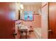 Bathroom features pink tiling, patterned wallpaper, and vintage fixtures at 111 Orangeview Ave, Clearwater, FL 33755