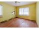 Bedroom with yellow walls, hardwood floors, and natural light from windows at 111 Orangeview Ave, Clearwater, FL 33755