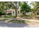 Front exterior view of a single story home with an attached carport, mature landscaping, and a sidewalk at 111 Orangeview Ave, Clearwater, FL 33755