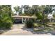 Single-story home with a covered parking spot and mature landscaping at 111 Orangeview Ave, Clearwater, FL 33755