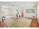 View of a living room with hardwood floors, an off-white rug, and large windows at 111 Orangeview Ave, Clearwater, FL 33755