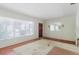 View of a living room with hardwood floors, an off-white rug, and large windows at 111 Orangeview Ave, Clearwater, FL 33755