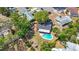 Aerial view of a home with a pool, fenced yard, and mature trees in a suburban neighborhood at 1159 19Th Sw Ave, Largo, FL 33778