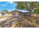 A single-story residential home has a tan exterior, a brown garage door, and a large tree in the front yard at 1159 19Th Sw Ave, Largo, FL 33778