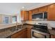 Traditional kitchen featuring stainless steel appliances, granite countertops, and wooden cabinetry at 1159 19Th Sw Ave, Largo, FL 33778