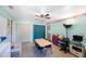 Playroom featuring neutral tile floors, a ceiling fan, a purple storage unit and a light blue color scheme at 1159 19Th Sw Ave, Largo, FL 33778