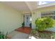Inviting front entrance featuring a decorative door, potted plants, and a tiled walkway, creating a warm welcome at 12453 138Th N St, Largo, FL 33774