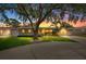 Charming single-story home with a well-manicured lawn, mature tree and attached garage at sunset at 12453 138Th N St, Largo, FL 33774