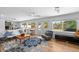 Bright living area with large windows, hardwood floors, stylish furniture, and easy access to the outdoor pool area at 12453 138Th N St, Largo, FL 33774