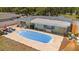 Aerial view of a backyard pool and patio area with outdoor kitchen and lounge furniture at 12453 138Th N St, Largo, FL 33774