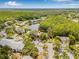 Overhead view of community featuring mature trees, a central lake, and well-maintained buildings at 1281 Pine Ridge E Cir # H1, Tarpon Springs, FL 34688