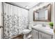 Bright bathroom featuring a white vanity, light grey walls, and a patterned shower curtain at 1281 Pine Ridge E Cir # H1, Tarpon Springs, FL 34688