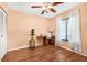 Bedroom with hardwood floors, ceiling fan, window, and a sewing station at 1281 Pine Ridge E Cir # H1, Tarpon Springs, FL 34688