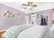 Bright bedroom featuring a ceiling fan, light purple walls, and a walk-in closet at 1281 Pine Ridge E Cir # H1, Tarpon Springs, FL 34688