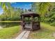 A charming gazebo near the lake offers a peaceful retreat surrounded by nature at 1281 Pine Ridge E Cir # H1, Tarpon Springs, FL 34688