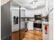 Well-lit kitchen with stainless steel appliances, white cabinetry and hardwood floors at 1281 Pine Ridge E Cir # H1, Tarpon Springs, FL 34688