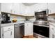 A well-lit kitchen featuring stainless steel appliances, white cabinets, and laminate countertops at 1281 Pine Ridge E Cir # H1, Tarpon Springs, FL 34688