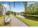 A serene walking path by the lake features a bench for relaxing and enjoying the view at 1281 Pine Ridge E Cir # H1, Tarpon Springs, FL 34688